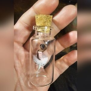 collectible miniature ballerina figurine housed inside a small glass bottle
